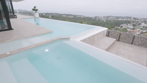 Incline-Hacia-Abajo-La-Vista-Desde-Las-Palmeras-Para-Revelar-Una-Villa-De-Lujo-Con-Piscina-Con-Vistas-A-Calp,-España