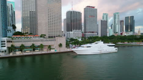 Drohne-Fliegt-über-Der-Wasseroberfläche-Und-über-Der-Weißen-Megayacht,-Die-In-Der-Biscayne-Bay-Festgemacht-Ist