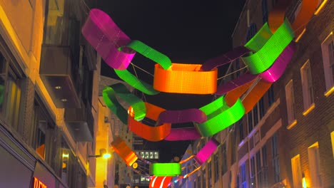 Cadenas-De-Papel-De-Color-Neón-Que-Cuelgan-Sobre-La-Calle-De-Carnaby-Durante-La-Noche-De-Navidad-En-El-Distrito-De-Soho,-Londres