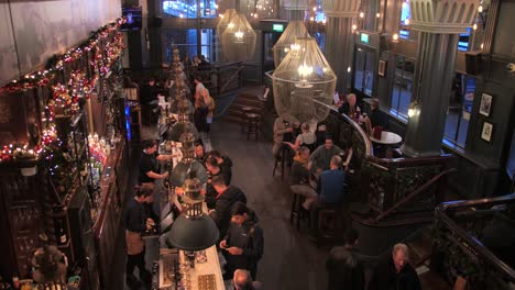 High-angle-shot-over-beautiful-interior-during-Christmas-season-inside-Horniman-pub-in-Hay's-Galleria-in-London,-UK-on-a-busy-day