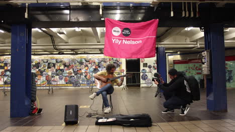 Creador-De-Contenido-Filmando-A-Un-Músico-Callejero-En-La-Plataforma-Del-Metro-De-Nueva-York