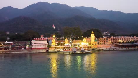 La-Orilla-Del-Río-Sagrado-Ganges-Llena-De-Templos-Religiosos-Al-Atardecer-Se-Toma-Un-Video-Aéreo-En-Parmarth-Niketan-Rishikesh-Uttrakhand-India-El-15-De-Marzo-De-2022