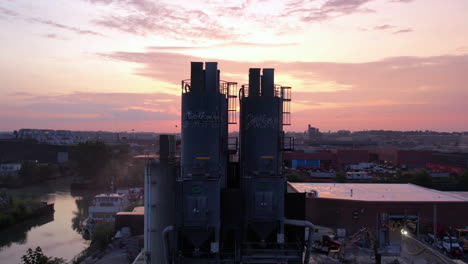 Vista-Aérea-De-La-Puesta-De-Sol-Sobre-Brooklyn-Nyc-Usa-Y-Silos-De-Planta-De-Concreto-Premezclado,-Revelando-Disparos-De-Drones-Descendentes-60fps