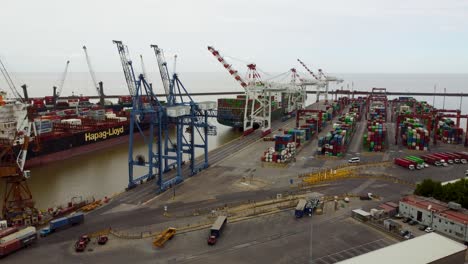 Aerial-parallax-of-shipping-containers-at-industrial-harbor,-Argentina