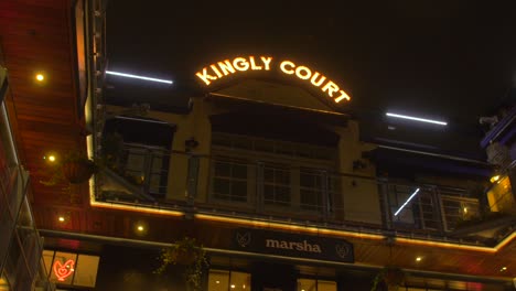 Low-angle-shot-from-right-to-left-of-Kingly-court-building-in-Carnaby-Street,-London,-UK-at-night-time