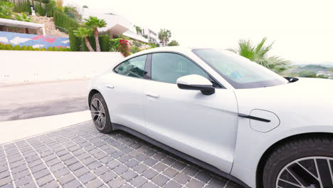 White-Porsche-Taycan-Approaching-Driveway-At-House-In-Calp,-Spain