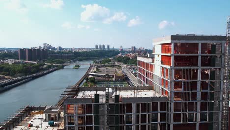 Aerial-view-over-the-Bronx-Point,-revealing-traffic-on-I-87-and-the-coast-of-the-Harlem-river,-in-sunny-NY,-USA---rising,-tilt,-drone-shot