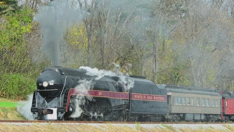 A-View-of-a-Steam-Passenger-Train-Stopped-on-a-Cold-Fall-Day-With-Lots-of-Smoke-and-Steam