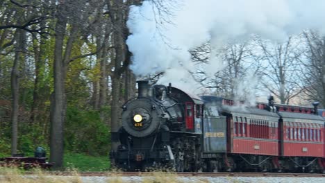 Una-Vista-De-Un-Tren-De-Pasajeros-De-Vapor-Que-Se-Acerca-Desde-Una-Larga-Distancia-En-Un-Frío-Día-De-Otoño-Con-Mucho-Humo