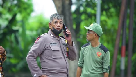 Police-officer-is-talking-on-mobile-phone-by-wearing-a-black-mask