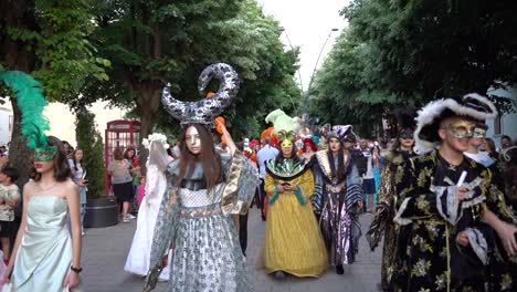 Charmante-Junge-Frauen-Und-Männer-In-Karnevalskostümen,-Hüten-Und-Federn-Stadtparade,-Zeitlupe