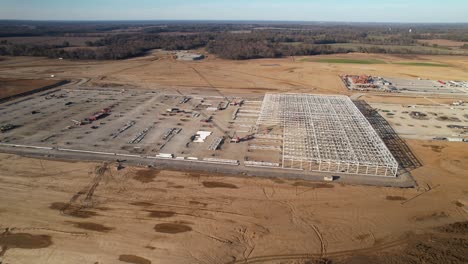 Aerial-orbit-of-steel-structure-under-construction-surrounded-by-heavy-machinery-and-cranes