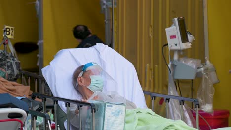 Un-Paciente-Con-Síntomas-De-Covid-19-Descansa-Mientras-Se-Acuesta-En-La-Cama-Fuera-De-Un-Hospital-Abarrotado-Mientras-El-Sistema-Médico-Colapsa-Con-Las-Hospitalizaciones