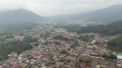 Aerial-view-over-the-cityscape-towards-the-Estadio-Pensativo-stadium-in-Antigua,-Guatemala