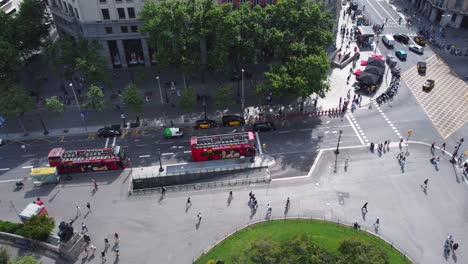 Above-the-city-of-Barcelona-at-the-busy-Catalonia-Square-with-a-red-city-bus-in-the-background-at-the-park