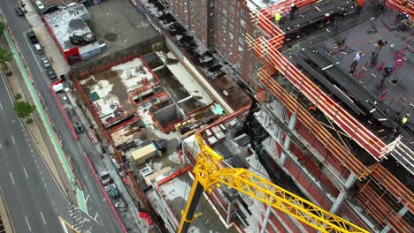 Material-De-Elevación-Con-Grúa-Para-Trabajadores-En-La-Parte-Superior-De-Una-Estructura-En-Queens,-Nueva-York---Vista-Aérea