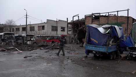 Los-Trabajadores-Pasan-Junto-A-Un-Cráter-De-Misiles-Rusos-S-300,-Un-Garaje-Destruido-Y-Vehículos-En-Una-Estación-De-Autobuses