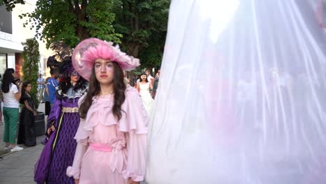 Carnival-parade-on-city-street,-beautiful-women-with-colorful-costumes-and-masks