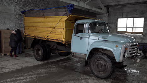 Voluntarios-Cargan-Cajas-De-Ayuda-En-Un-Viejo-Camión-En-Un-Almacén