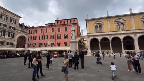 Toma-Panorámica-De-Personas-En-Piazza-Dei-Lordi-Plaza-Popular-De-Verona-Ciudad-Italiana-Con-Estatua-De-Dante-Alighieri-En-El-Centro