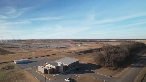 Aerial-ascending-reveal-of-sprawling-new-construction-behind-fire-station