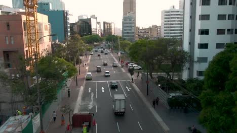 Toma-Aérea-Sobre-Una-Avenida-San-Isidro,-Lima,-Perú-Cerca-Del-Suelo-Y-Entre-Edificios