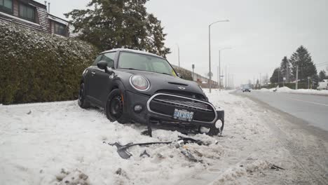 Coche-Estrellado-En-La-Acera-Al-Lado-De-Un-Camino-Nevado