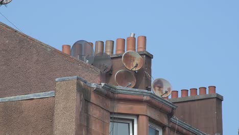 Toma-De-Primer-Plano-De-Un-Grupo-De-Antenas-De-Televisión-En-El-Techo-De-Una-Vivienda