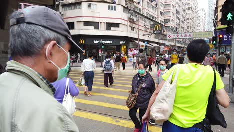 Pandemia-De-Corona,-Personas-Que-Cruzan-La-Calle-En-El-Centro-De-Hong-Kong-Con-Máscaras-Protectoras-Durante-El-Brote-Del-Virus-De-La-Corona