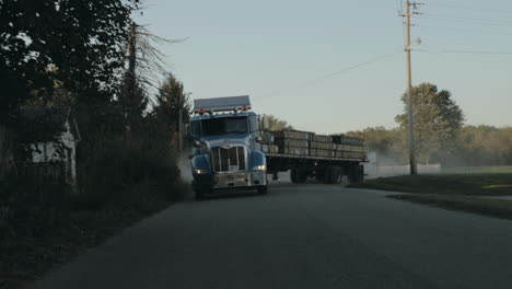 Peterbilt-semi-truck-pulling-out-of-yard-and-driving-down-the-street-front-view