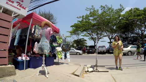 Local-Thai-people-passing-by-on-foot-and-in-vehicles-on-beach-road-in-Cha-am-Thailand