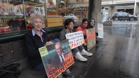 Acción-Climática,-Emergencia-Climática,-Pánico-Climático,-Cartel-De-Scott-Morrison,-Manifestantes-Climáticos-Pacíficos-Jóvenes-Y-Viejos-En-El-Lluvioso-Sydney,-Bloqueado-Bajo-Gran-Angular-Primer-Plano