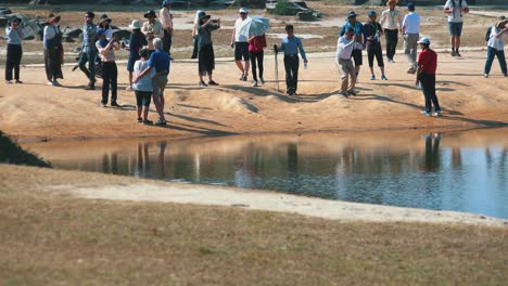 Plano-Medio-De-Turista-Tomando-Fotos-Cerca-De-Un-Lago