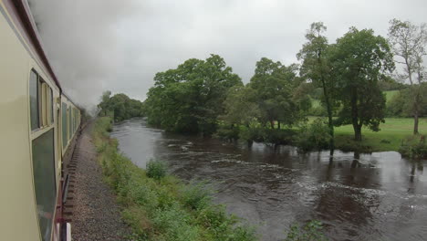 View-out-South-Devon-Railway-train-traveling-along-River-Dart,-POV