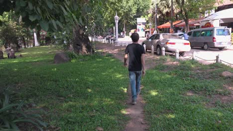 Male-Tourist-Walking-on-the-Grass-Near-the-River