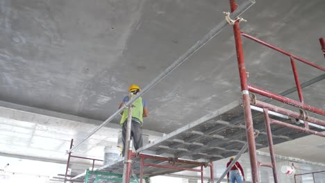 Bauarbeiter-Führen-Auf-Der-Baustelle-Deckenuntersichtsspachtelarbeiten-Durch