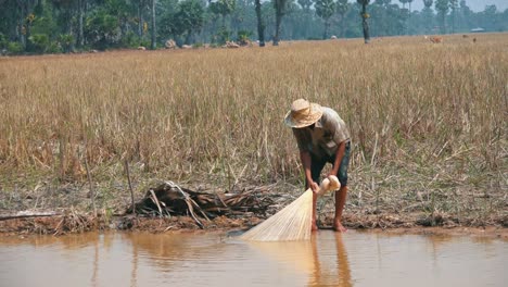 Fischer-Zieht-Sein-Netz-Aus-Dem-Wasser-Und-Prüft,-Ob-Er-Etwas-Gefangen-Hat