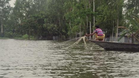 Ein-Boot-Fährt-Durchs-Wasser-Und-Eine-Person-Breitet-Netze-Aus,-Um-Fische-Zu-Fangen