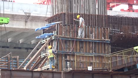 Bauarbeiter,-Die-In-Der-Höhe-Arbeiten,-Installieren-Bewehrungsstäbe-Und-Schalungsarbeiten-Auf-Der-Baustelle