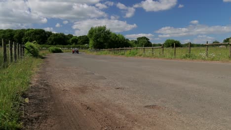 Red-1939-Morgan-4-4-'Le-Mans'---drive-past-on-quiet-road---SLOMO---open-top-sports-car-in-English-countryside-on-a-picture-perfect-day