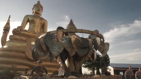 Landmark-and-viewpoint-golden-Statue-of-Buddha-with-snakes-at-the-Big-Buddha-monument-in-Phuket,-Thailand----Blue-sky-and-bird-crossing-the-pan-shot----Stabilized-full-HD-wide-angle-Shot