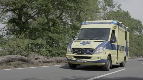 Ambulancia-Con-Señal-Intermitente-Pasando-Por-Carretera,-Cámara-Lenta