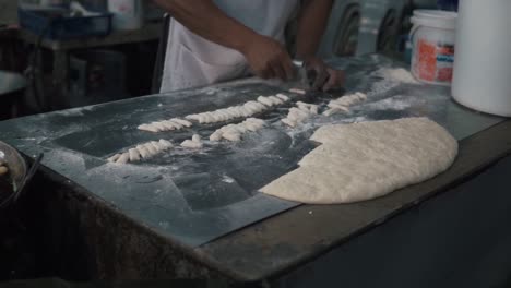 Comerciante-De-Comida-Callejera-Cortando-Masa-Para-Hacer-Palitos-De-Masa-Frita,-Comida-Callejera-En-Tailandia