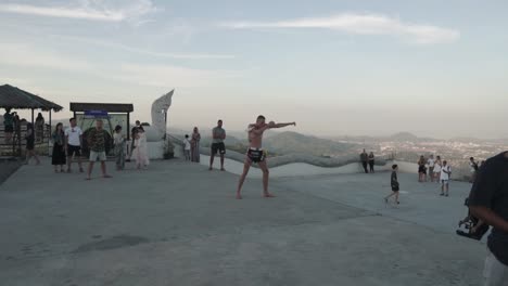 BTS----Music-video-production-at-the-landmark-and-viewpoint-Big-Buddha-Phuket,-Thailand----Steadyshot-from-side----Kickboxing-world-champion-showing-off-his-skills----Shadow-fighting