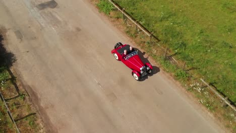 Rojo-1939-Morgan-4-4-&#39;le-Mans&#39;---Vista-Lateral-Del-Dron-Del-Pasajero-Del-Conductor---4k---Coche-Deportivo-Descapotable-En-La-Campiña-Inglesa