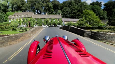 Rojo-1939-Morgan-4-4-&#39;le-Mans&#39;---Vista-Del-Capot-Pasando-Por-El-Puente---Slomo---Coche-Deportivo-Descapotable-En-La-Campiña-Inglesa-En-Un-Día-Perfecto