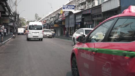 Movement----Pink-taxi-cab-passing-tuk-tuk-in-Bangkok-Thailand----touristic-area,-Khao-San-Road----taxi-car-passing-the-shot----Stabilized-full-HD-shot