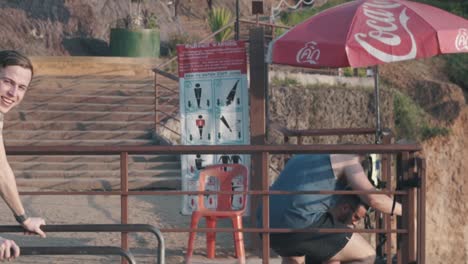 Young-man-laughing-with-his-friends-playing-on-smartphone-in-Krabi-Thailand-in-slow-motion