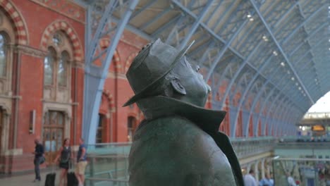 Mann-Hält-Hut-An-Kopf---Betjeman-In-St.-Pancras,-London---Slomo-60fps