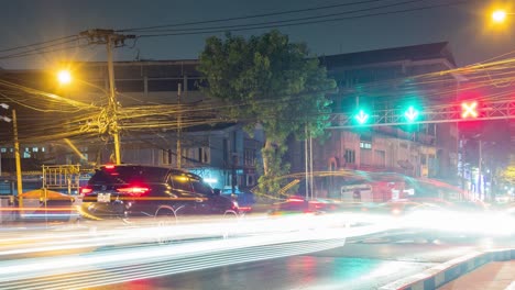 Coches-De-Lapso-De-Tiempo-Que-Se-Mueven-A-Través-De-Una-Intersección-De-Bangkok-En-La-Noche